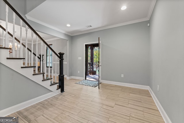 foyer entrance featuring baseboards, ornamental molding, visible vents, and stairway