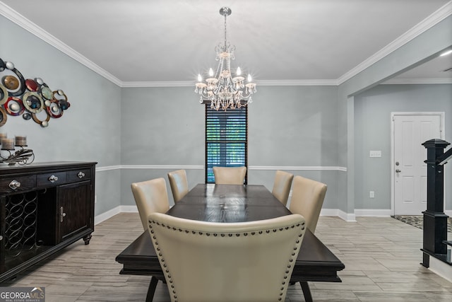 dining space featuring light wood-style flooring, ornamental molding, baseboards, and an inviting chandelier