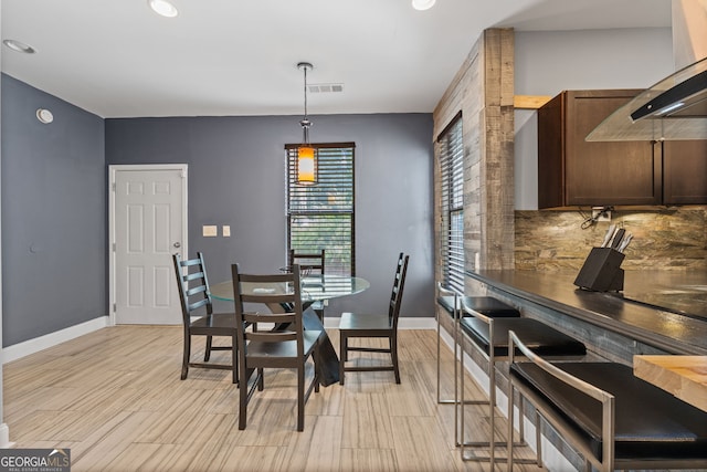 dining area featuring light wood-style floors, baseboards, and visible vents