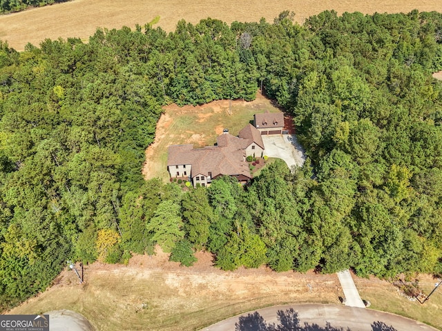 birds eye view of property featuring a forest view
