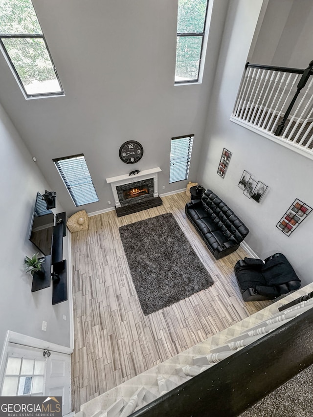 living room featuring hardwood / wood-style flooring and a towering ceiling