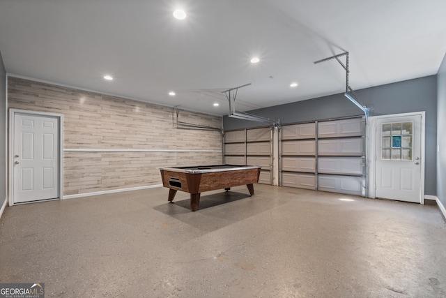 garage with wood walls, recessed lighting, and baseboards