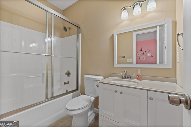 bathroom featuring combined bath / shower with glass door, tile patterned floors, vanity, and toilet
