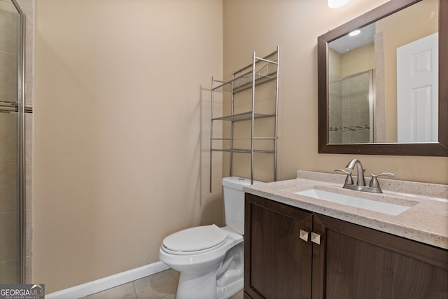 bathroom with tile patterned floors, a shower with shower door, vanity, and toilet