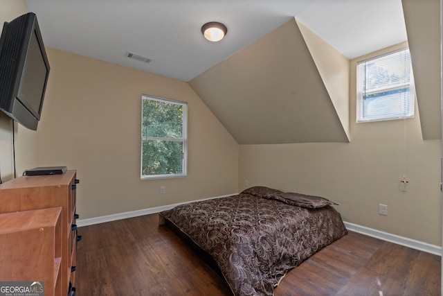 bedroom with wood finished floors, baseboards, lofted ceiling, and visible vents