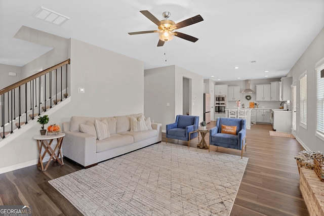 living room with wood-type flooring, ceiling fan, and sink