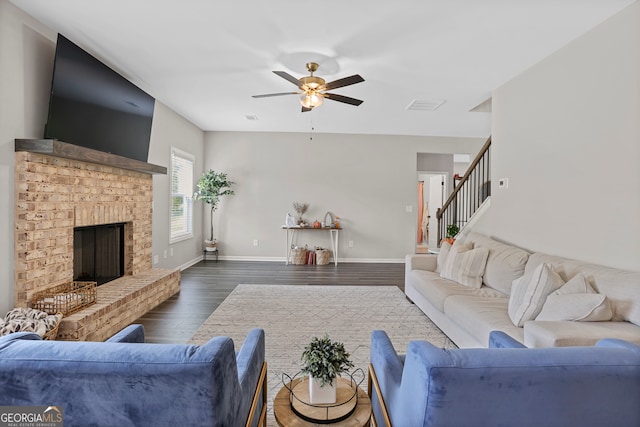 living room featuring a fireplace, dark hardwood / wood-style floors, and ceiling fan