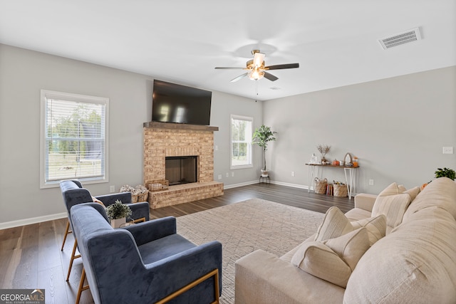 living room with a fireplace, dark hardwood / wood-style floors, and ceiling fan