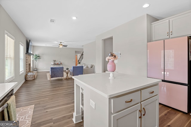 kitchen with a center island, hardwood / wood-style floors, ceiling fan, and white fridge