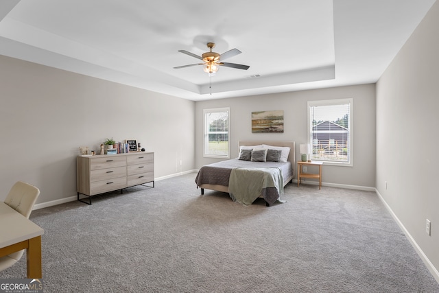 bedroom featuring a tray ceiling, ceiling fan, and light colored carpet