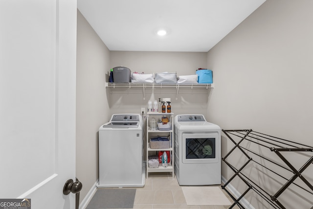 laundry room with washer and clothes dryer and light tile patterned floors