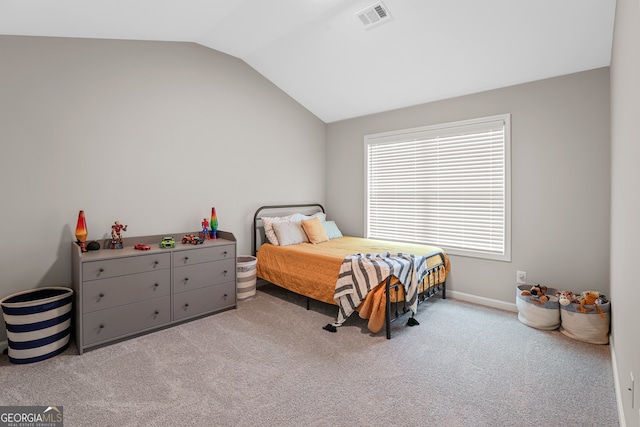 bedroom with vaulted ceiling and light colored carpet