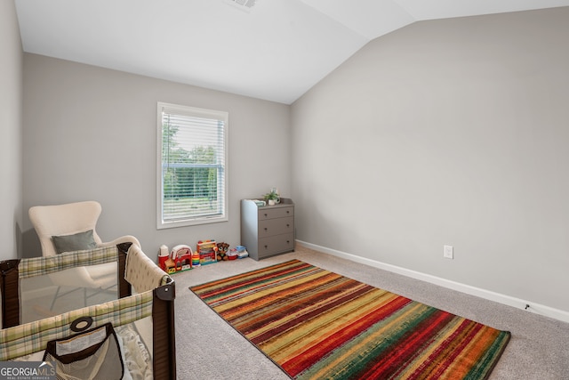 bedroom featuring lofted ceiling and carpet