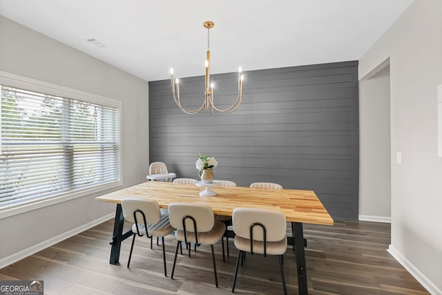 dining space with dark hardwood / wood-style floors and a chandelier