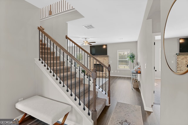 stairway featuring wood-type flooring and ceiling fan