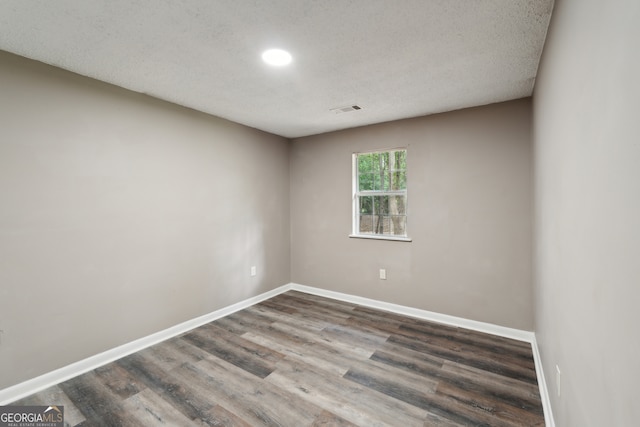 spare room featuring a textured ceiling and hardwood / wood-style floors