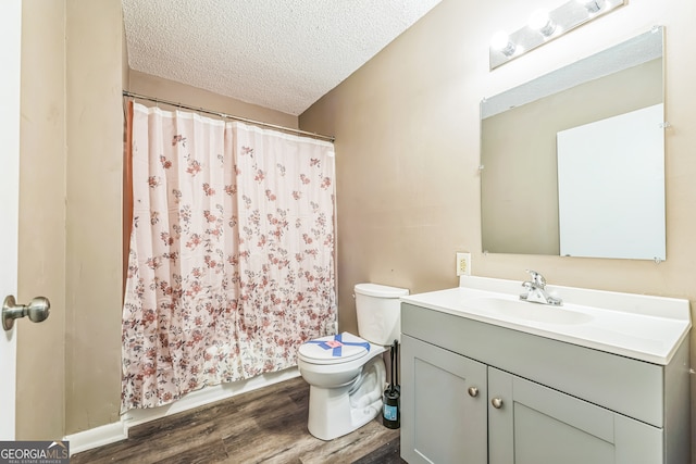 bathroom with vanity, a textured ceiling, hardwood / wood-style flooring, walk in shower, and toilet