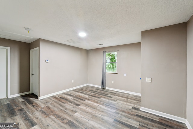 unfurnished room with a textured ceiling and hardwood / wood-style flooring