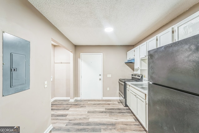 kitchen featuring white cabinets, black fridge, light wood-type flooring, electric panel, and stainless steel electric range oven