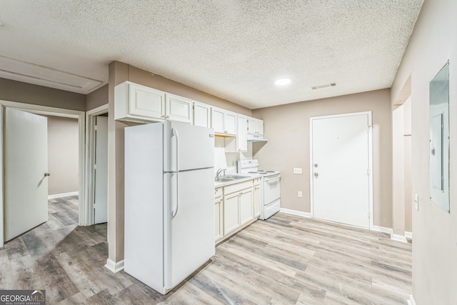 kitchen with a textured ceiling, light hardwood / wood-style flooring, white appliances, and white cabinetry