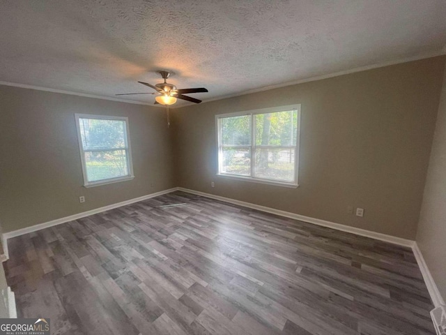 spare room featuring ornamental molding, hardwood / wood-style floors, ceiling fan, and a wealth of natural light