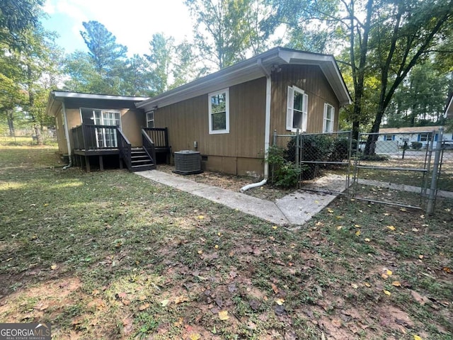 rear view of house with a yard and central air condition unit