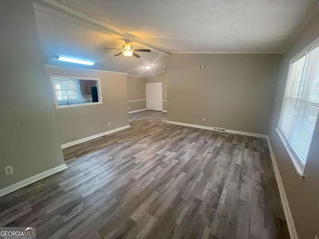 interior space featuring lofted ceiling with beams, ceiling fan, crown molding, and dark hardwood / wood-style flooring