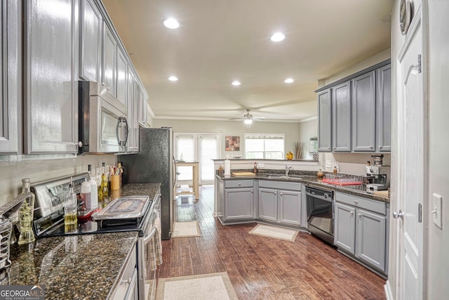 kitchen with ornamental molding, kitchen peninsula, gray cabinetry, stainless steel appliances, and dark hardwood / wood-style flooring