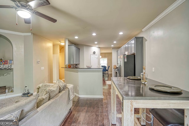 kitchen with stainless steel refrigerator, dark hardwood / wood-style floors, ornamental molding, and gray cabinetry