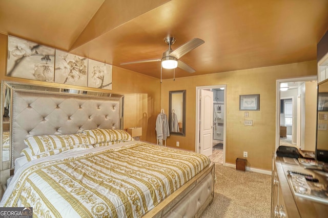 bedroom featuring vaulted ceiling, ensuite bathroom, ceiling fan, and light colored carpet