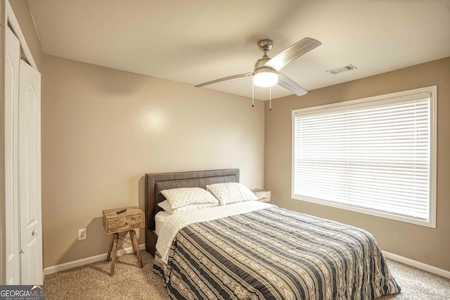 carpeted bedroom featuring ceiling fan and a closet