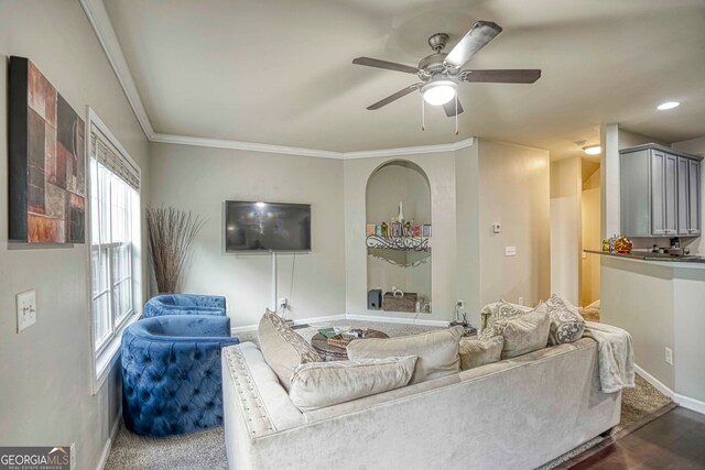 living room with ornamental molding, ceiling fan, and dark wood-type flooring