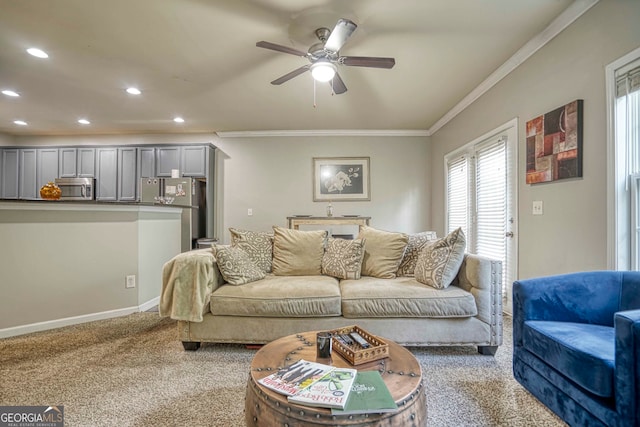 living room featuring carpet floors, ornamental molding, and ceiling fan