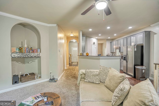 carpeted living room featuring crown molding and ceiling fan