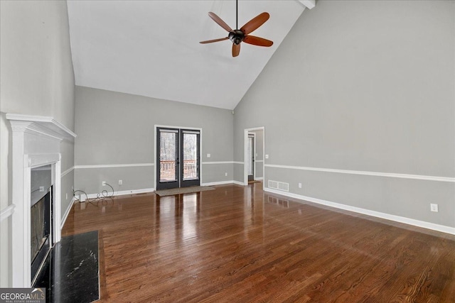 unfurnished living room featuring baseboards, visible vents, wood finished floors, a fireplace, and high vaulted ceiling