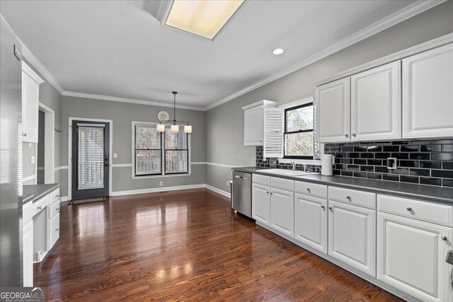 kitchen with tasteful backsplash, dark countertops, stainless steel dishwasher, dark wood-type flooring, and white cabinetry