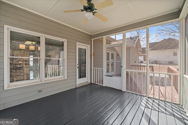 unfurnished sunroom featuring ceiling fan