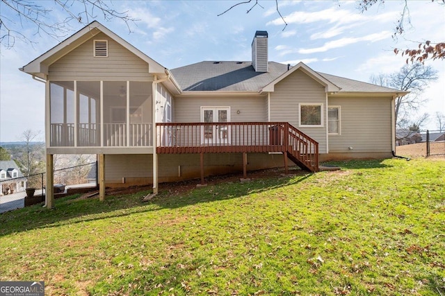 back of property with a wooden deck, a lawn, fence, and a sunroom