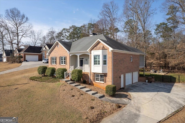 view of front of home with concrete driveway, brick siding, a chimney, and an attached garage