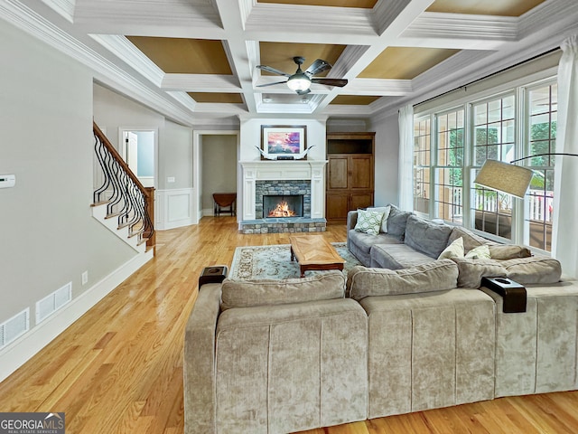 living room featuring coffered ceiling, hardwood / wood-style flooring, beam ceiling, and ornamental molding