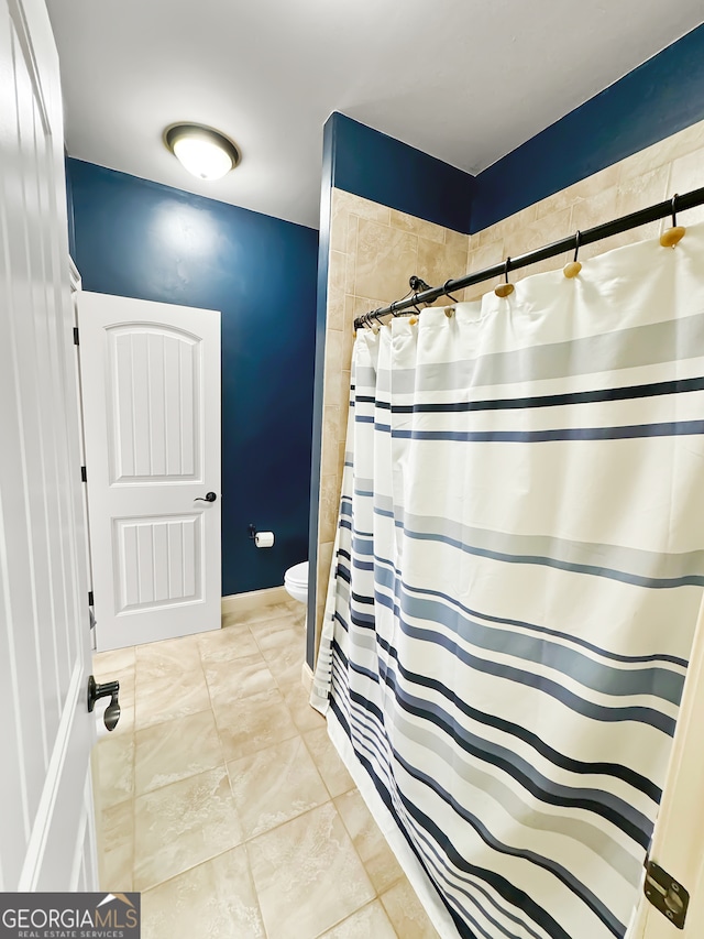 bathroom featuring curtained shower and toilet