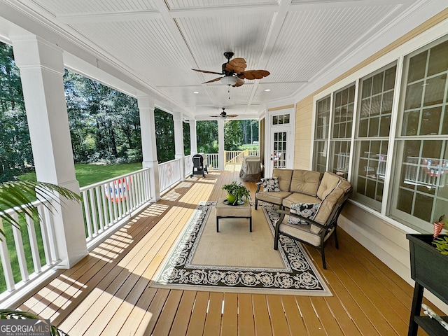 wooden terrace with an outdoor living space, ceiling fan, and covered porch