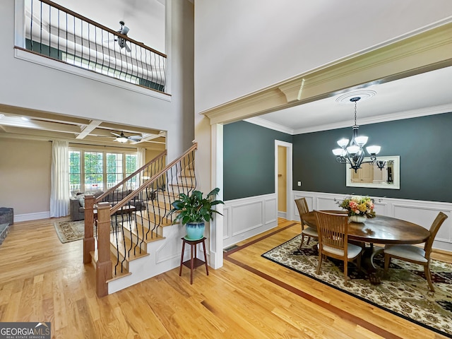 dining room with coffered ceiling, ceiling fan with notable chandelier, beam ceiling, hardwood / wood-style flooring, and ornamental molding