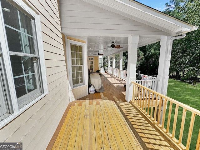 wooden deck featuring ceiling fan and a lawn