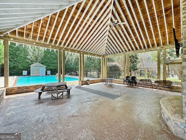 view of patio featuring a storage shed and a fenced in pool