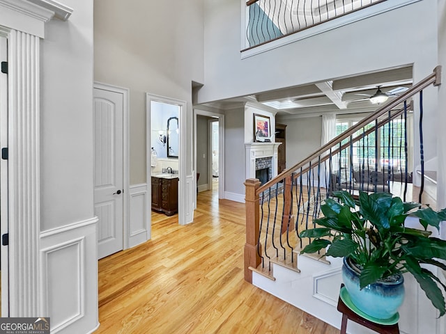 interior space featuring ceiling fan, sink, beam ceiling, coffered ceiling, and hardwood / wood-style flooring