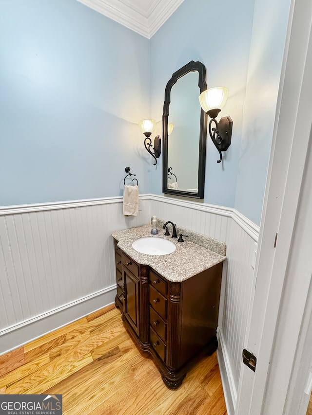 bathroom with ornamental molding, vanity, and hardwood / wood-style floors