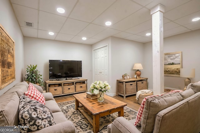 living room with a drop ceiling and hardwood / wood-style flooring