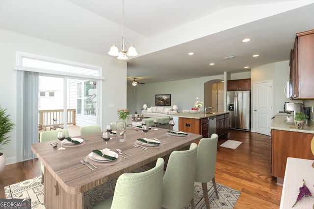 dining room featuring ceiling fan with notable chandelier, dark hardwood / wood-style flooring, and sink