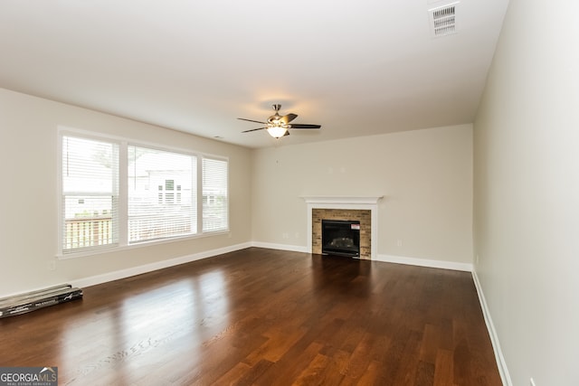 unfurnished living room featuring ceiling fan and dark hardwood / wood-style flooring